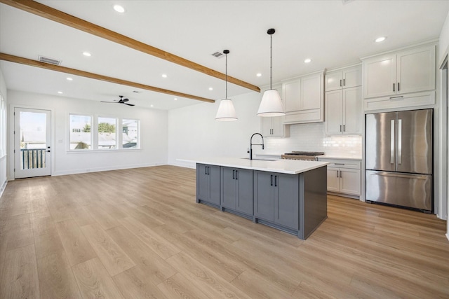 1201 E 27th St, Houston, TX 77009 - kitchen featuring stainless steel fridge, beamed ceiling, a sink, light countertops, and recessed lighting