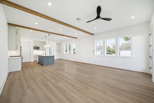 1201 E 27th St, Houston, TX 77009 - unfurnished living room featuring a sink, beam ceiling, a ceiling fan, light wood finished floors, and recessed lighting