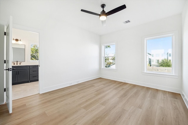 1201 E 27th St, Houston, TX 77009 - unfurnished room with light wood-style flooring, plenty of natural light, a ceiling fan, and baseboards