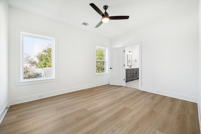 1201 E 27th St, Houston, TX 77009 - unfurnished bedroom with light wood-style flooring, baseboards, connected bathroom, and ceiling fan