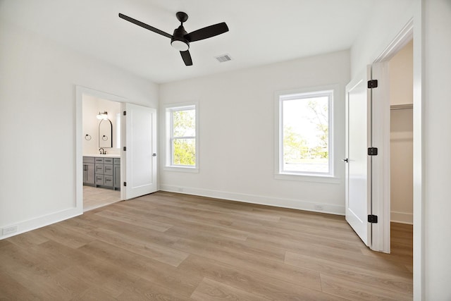 1203 E 27th St, Houston, TX 77009 - unfurnished bedroom with light wood-style floors, baseboards, ensuite bathroom, a sink, and a ceiling fan