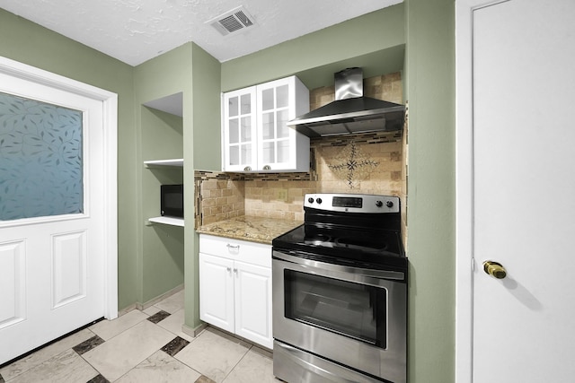 8030 Dodiewood Ln, Houston, TX 77086 - kitchen featuring stainless steel electric range oven, wall chimney exhaust hood, white cabinets, tasteful backsplash, and light stone countertops
