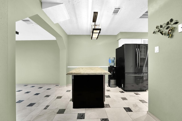 8030 Dodiewood Ln, Houston, TX 77086 - kitchen with freestanding refrigerator, a kitchen island, and white cabinetry