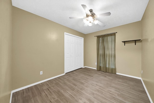 8030 Dodiewood Ln, Houston, TX 77086 - unfurnished bedroom with baseboards, light wood-type flooring, a closet, and a ceiling fan