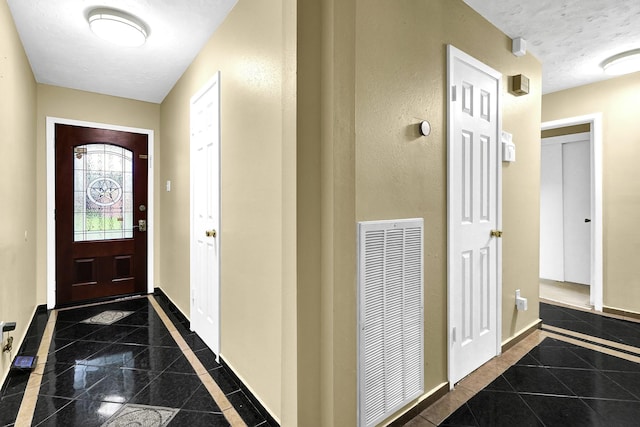 8030 Dodiewood Ln, Houston, TX 77086 - foyer with inlaid floor details, baseboards, granite tiled floors, and a textured ceiling