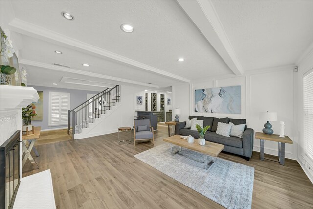 16111 Maplehurst Dr, Houston, TX 77379 - living room with stairs, a glass covered fireplace, beamed ceiling, wood finished floors, and baseboards