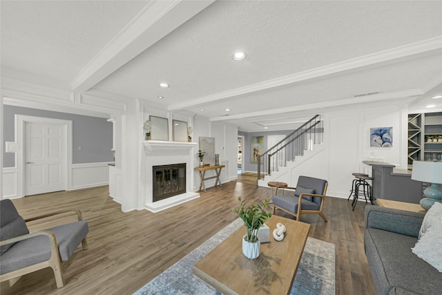16111 Maplehurst Dr, Houston, TX 77379 - living area featuring stairs, a decorative wall, wood finished floors, a glass covered fireplace, and beam ceiling