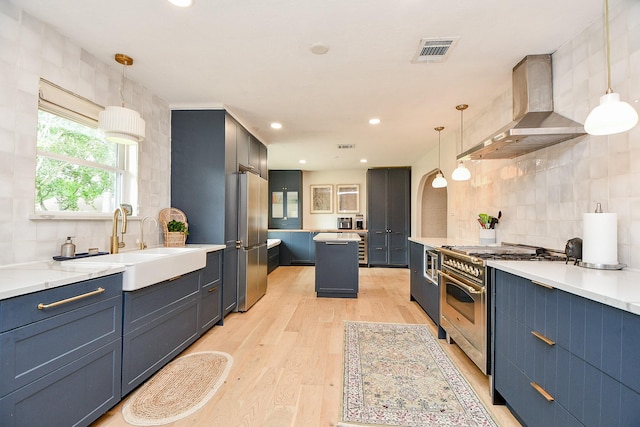 2735 Triway Ln, Houston, TX 77043 - kitchen with appliances with stainless steel finishes, wall chimney exhaust hood, tasteful backsplash, light wood-style flooring, and a sink