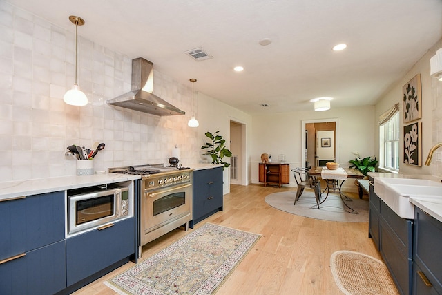 2735 Triway Ln, Houston, TX 77043 - kitchen featuring wall chimney exhaust hood, appliances with stainless steel finishes, a sink, blue cabinets, and backsplash