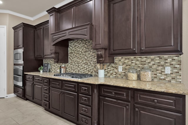 13518 Ambler Springs Dr, Tomball, TX 77377 - kitchen with stainless steel appliances, backsplash, dark brown cabinets, crown molding, and light stone counters
