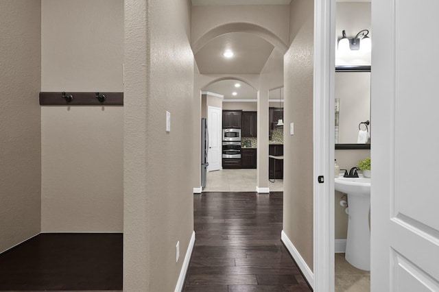13518 Ambler Springs Dr, Tomball, TX 77377 - hall featuring a textured wall, hardwood / wood-style flooring, arched walkways, and baseboards