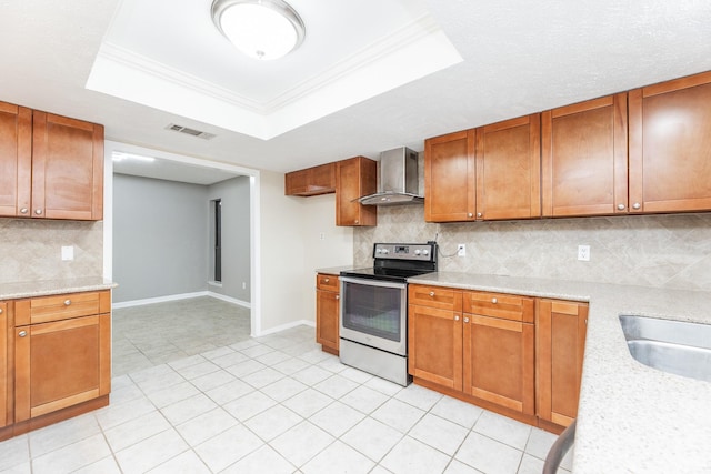 2543 Sage Brush Ln, Sugar Land, TX 77479 - kitchen with stainless steel electric range oven, wall chimney range hood, brown cabinets, baseboards, and a tray ceiling