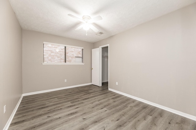 2543 Sage Brush Ln, Sugar Land, TX 77479 - unfurnished bedroom with wood finished floors, a textured ceiling, a closet, baseboards, and a ceiling fan