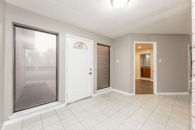 2543 Sage Brush Ln, Sugar Land, TX 77479 - entryway with baseboards, a textured ceiling, and light tile patterned floors