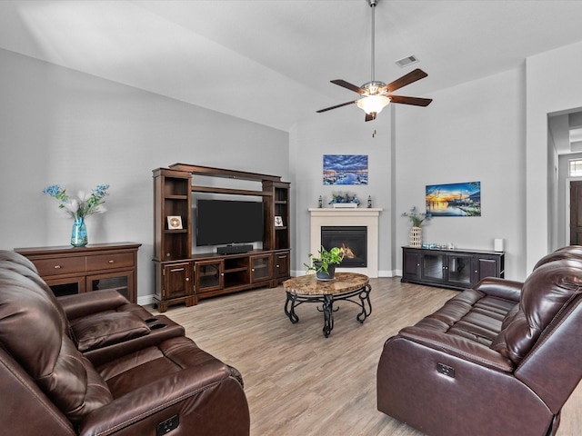 2314 Navo Ln, League City, TX 77573 - living area with wood finished floors, ceiling fan, a glass covered fireplace, lofted ceiling, and baseboards