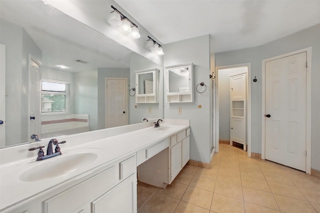 3218 Barkers Forest Ln, Houston, TX 77084 - bathroom with double vanity, tile patterned floors, baseboards, a closet, and a bath