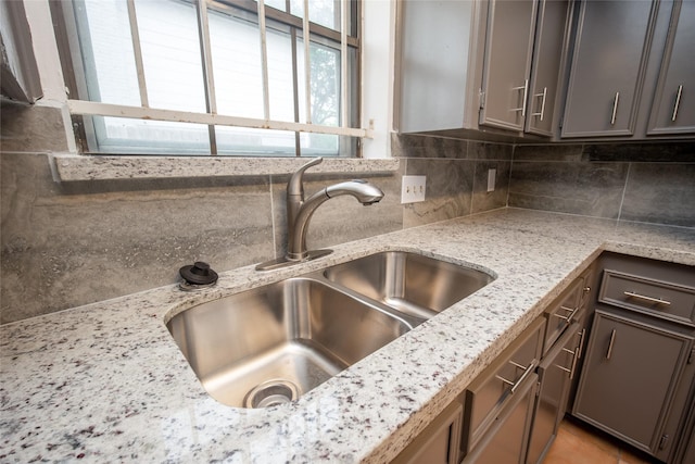 15319 Paseo Del Rey Dr, Houston, TX 77083 - kitchen view of a sink, decorative backsplash, and light stone counters