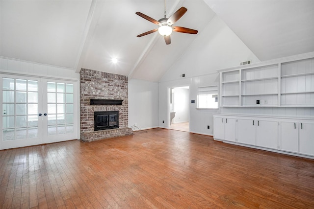 15319 Paseo Del Rey Dr, Houston, TX 77083 - unfurnished living room with high vaulted ceiling, a ceiling fan, light wood-style flooring, a brick fireplace, and french doors