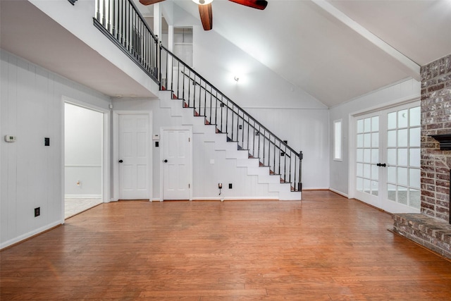 15319 Paseo Del Rey Dr, Houston, TX 77083 - unfurnished living room with wood finished floors, ceiling fan, high vaulted ceiling, stairway, and french doors