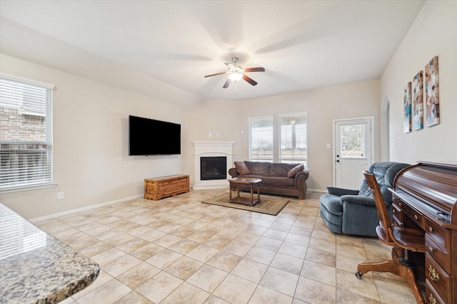 3707 Daintree Park Dr, Katy, TX 77494 - living area featuring ceiling fan, light tile patterned floors, a fireplace with raised hearth, and baseboards