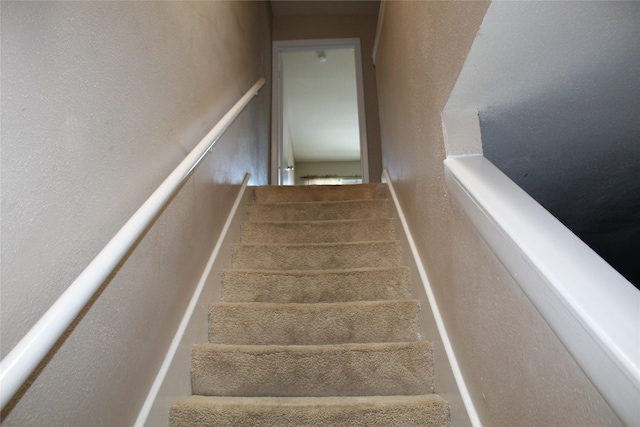 10001 Westpark Dr Unit 25, Houston, TX 77042 - stairs featuring a textured wall