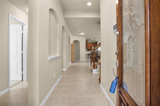 2602 Tacoma Springs Dr, Conroe, TX 77304 - corridor with arched walkways, light tile patterned flooring, baseboards, stairs, and recessed lighting