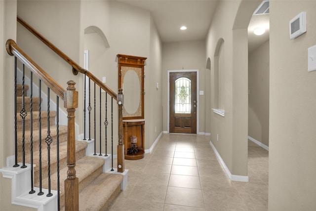 2602 Tacoma Springs Dr, Conroe, TX 77304 - foyer entrance featuring light tile patterned floors, baseboards, recessed lighting, arched walkways, and stairway