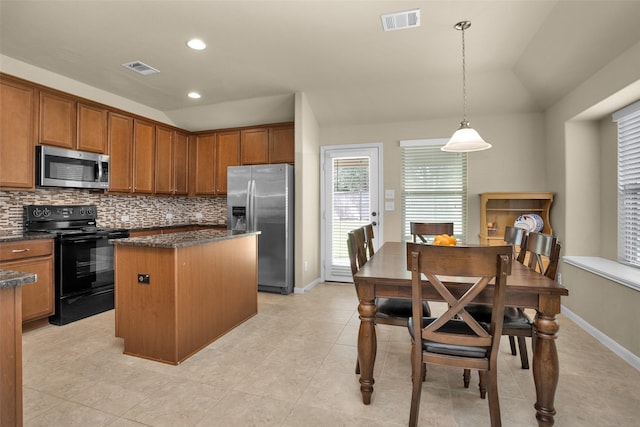 2602 Tacoma Springs Dr, Conroe, TX 77304 - kitchen featuring appliances with stainless steel finishes, a center island, lofted ceiling, backsplash, and brown cabinetry