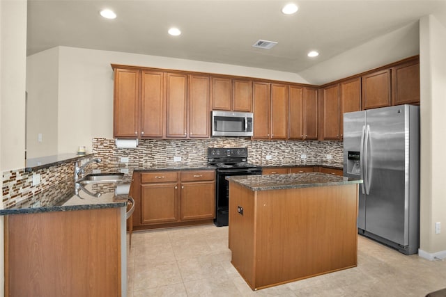 2602 Tacoma Springs Dr, Conroe, TX 77304 - kitchen with stainless steel appliances, a sink, a peninsula, dark stone counters, and vaulted ceiling