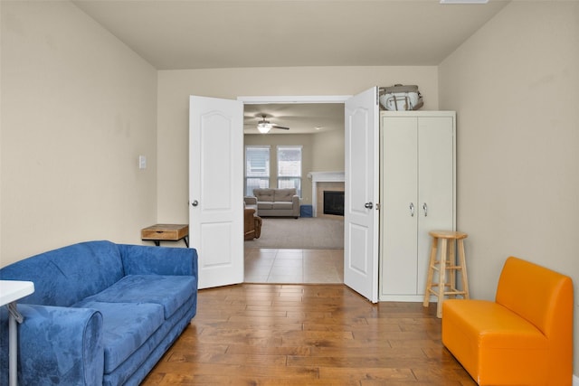 2602 Tacoma Springs Dr, Conroe, TX 77304 - sitting room featuring wood-type flooring, a tiled fireplace, and a ceiling fan