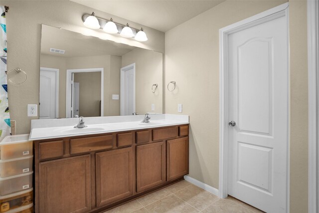 2602 Tacoma Springs Dr, Conroe, TX 77304 - bathroom with double vanity, tile patterned flooring, and baseboards