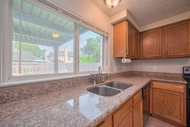 1806 Foxlake Dr, Houston, TX 77084 - kitchen with a sink, dishwasher, brown cabinetry, light stone counters, and light tile patterned floors