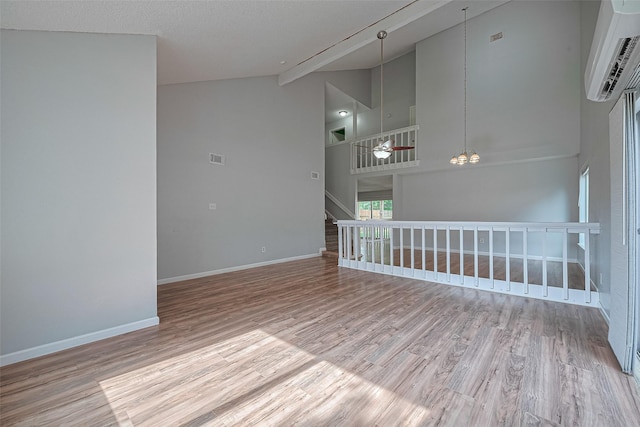 1806 Foxlake Dr, Houston, TX 77084 - spare room featuring a wall unit AC, wood finished floors, ceiling fan, baseboards, and high vaulted ceiling