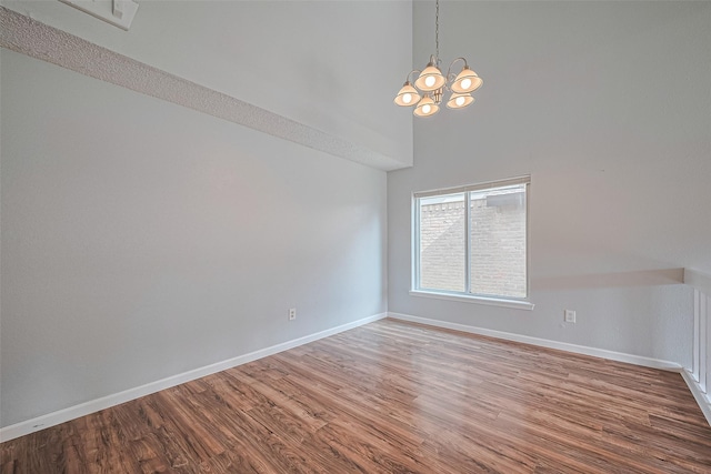 1806 Foxlake Dr, Houston, TX 77084 - spare room with a towering ceiling, wood finished floors, a chandelier, and baseboards
