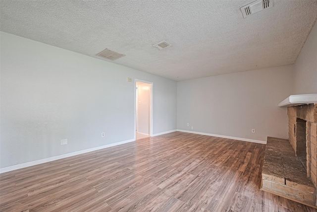 1806 Foxlake Dr, Houston, TX 77084 - unfurnished living room featuring wood finished floors, a fireplace, a textured ceiling, and baseboards