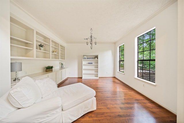 15 S Duskwood Pl, The Woodlands, TX 77381 - living room with ornamental molding, wood finished floors, built in shelves, a chandelier, and baseboards