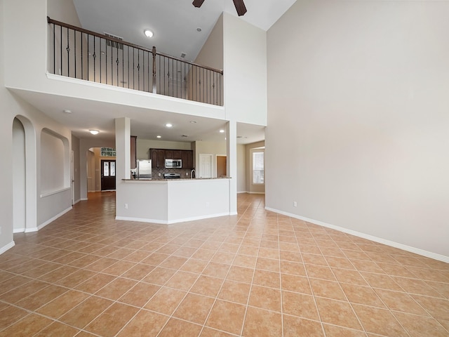 4015 Candle Cove Ct, Sugar Land, TX 77479 - unfurnished living room with light tile patterned floors, a ceiling fan, baseboards, high vaulted ceiling, and recessed lighting