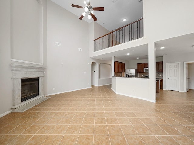 4015 Candle Cove Ct, Sugar Land, TX 77479 - unfurnished living room featuring ceiling fan, high vaulted ceiling, light tile patterned floors, a tile fireplace, and baseboards