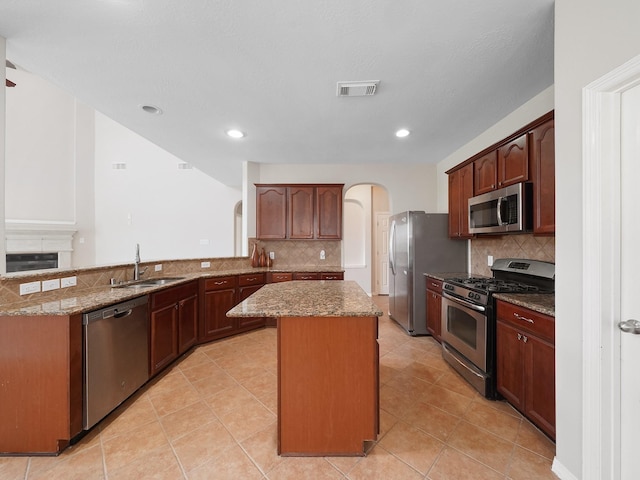 4015 Candle Cove Ct, Sugar Land, TX 77479 - kitchen with stainless steel appliances, a sink, a kitchen island, stone counters, and recessed lighting