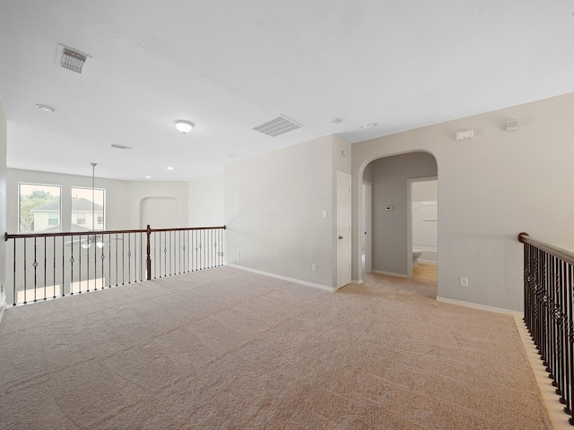 4015 Candle Cove Ct, Sugar Land, TX 77479 - spare room with arched walkways, baseboards, light carpet, and recessed lighting