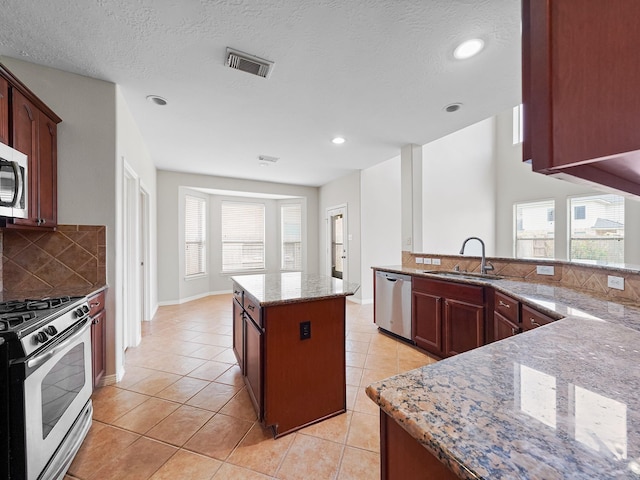 4015 Candle Cove Ct, Sugar Land, TX 77479 - kitchen with appliances with stainless steel finishes, a sink, light tile patterned floors, decorative backsplash, and recessed lighting