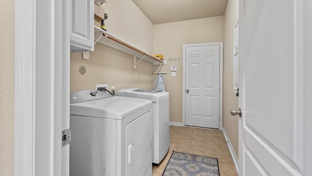 13822 Birney Point Ln, Houston, TX 77044 - washroom with washer and dryer, cabinet space, light tile patterned flooring, and baseboards