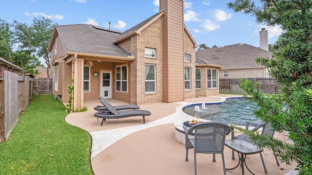 13822 Birney Point Ln, Houston, TX 77044 - rear view of house with a patio, roof with shingles, a chimney, a fire pit, and roof mounted solar panels