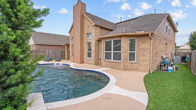 13822 Birney Point Ln, Houston, TX 77044 - back of property featuring central AC unit, a patio, a chimney, brick siding, and roof with shingles