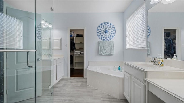 13822 Birney Point Ln, Houston, TX 77044 - full bathroom featuring a garden tub, vanity, a spacious closet, and a stall shower