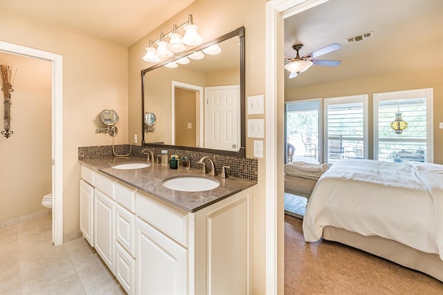 1927 E Lake Dr, Huntsville, TX 77340 - full bathroom featuring a ceiling fan, double vanity, toilet, connected bathroom, and decorative backsplash