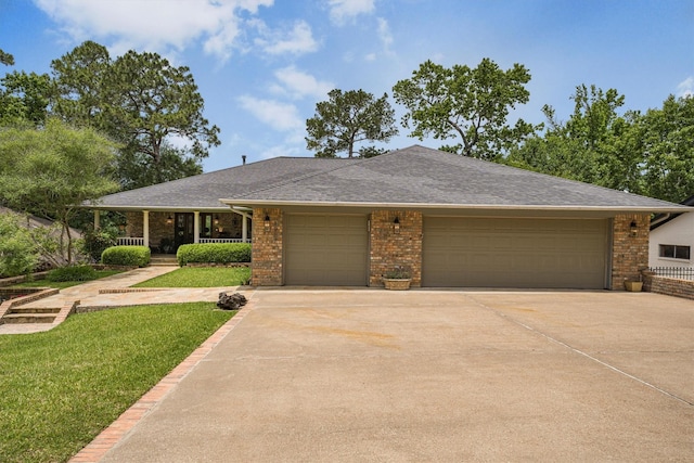 1927 E Lake Dr, Huntsville, TX 77340 - ranch-style home featuring an attached garage, driveway, brick siding, a front lawn, and a shingled roof