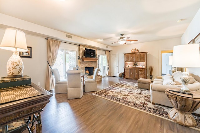 1927 E Lake Dr, Huntsville, TX 77340 - living room featuring a fireplace, ceiling fan, and wood finished floors