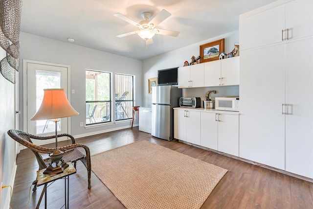 1927 E Lake Dr, Huntsville, TX 77340 - kitchen featuring white microwave, freestanding refrigerator, ceiling fan, and dark wood-style floors