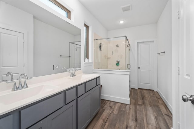 19180 Cedar Lennox Cir, Magnolia, TX 77355 - bathroom featuring a shower stall, wood finished floors, double vanity, and baseboards